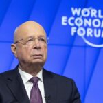 Klaus Schwab speaking at the World Economic Forum, WEF logo in the background.