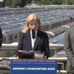 Jessica Tisch, NYPD Commissioner, and Mayor Eric Adams at a press briefing on community safety, standing before NYC subway trains.