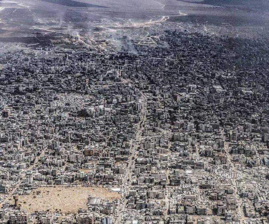 Aerial view of Gaza city destruction showing damaged buildings, smoke, and debris after prolonged conflict.